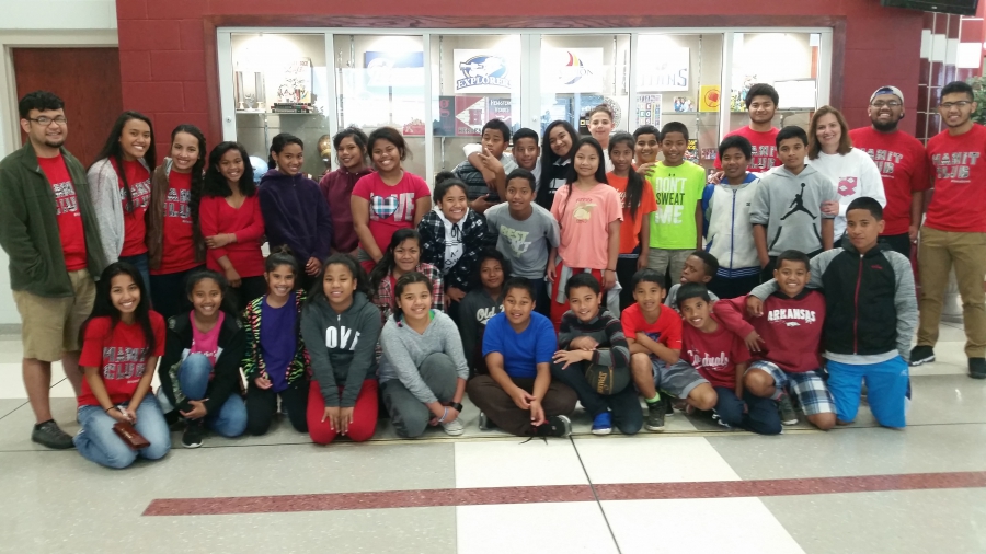 A group photo of college-age students with their young mentees